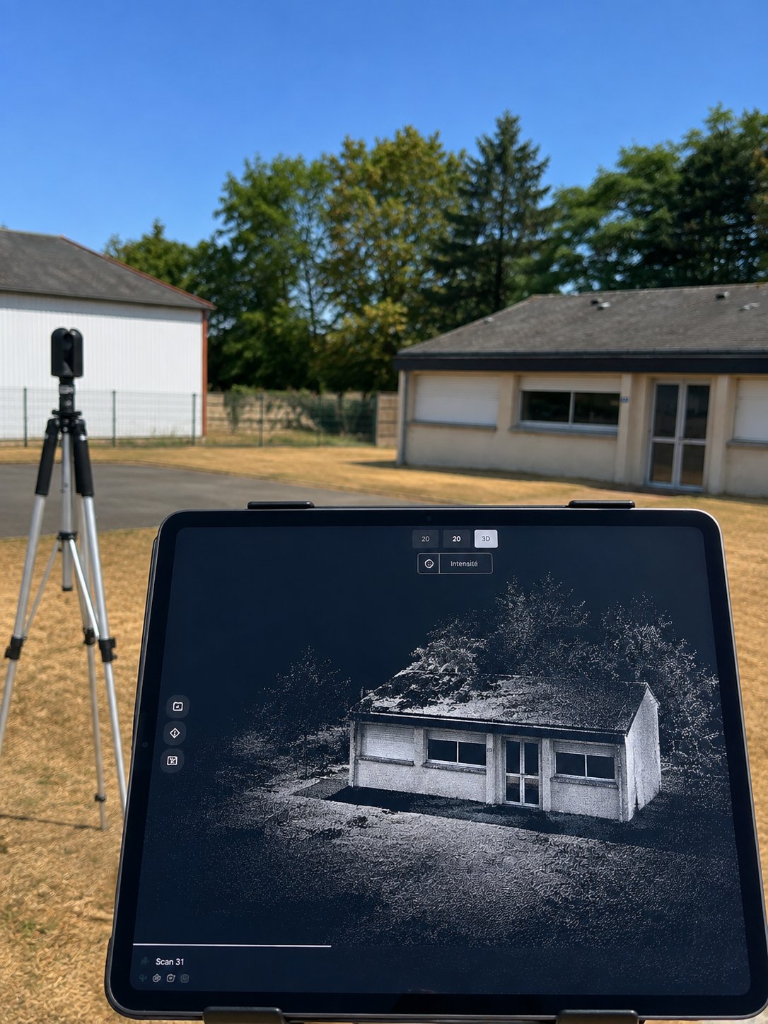 Relevé sur site : le scanner laser sur trépied et, sur la tablette, le nuage de points du bâtiment qui se construit en direct.